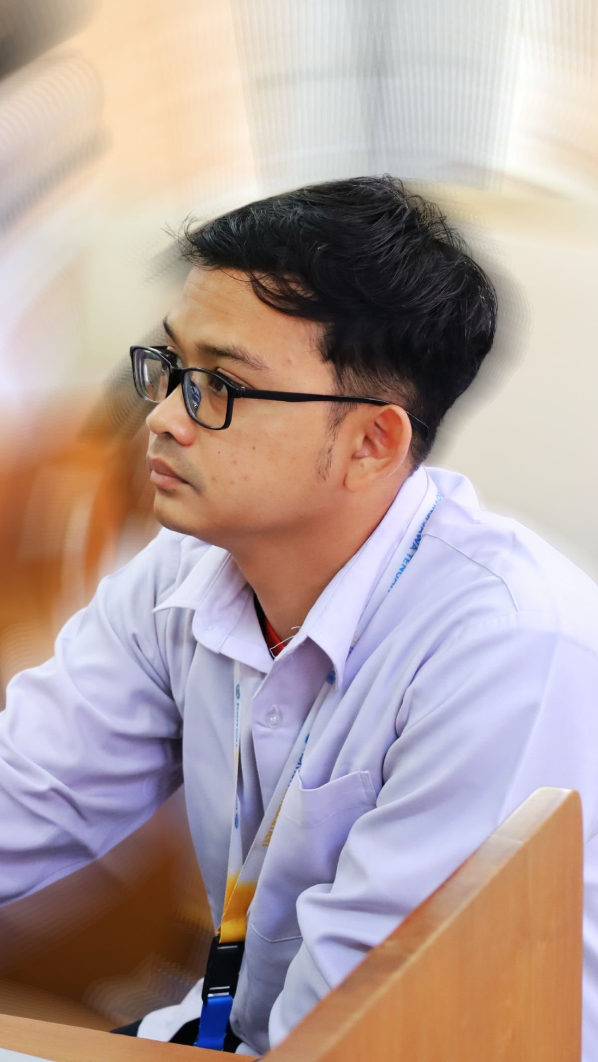 Peserta laki-laki berkacamata menyimak materi dalam ruang pelatihan.