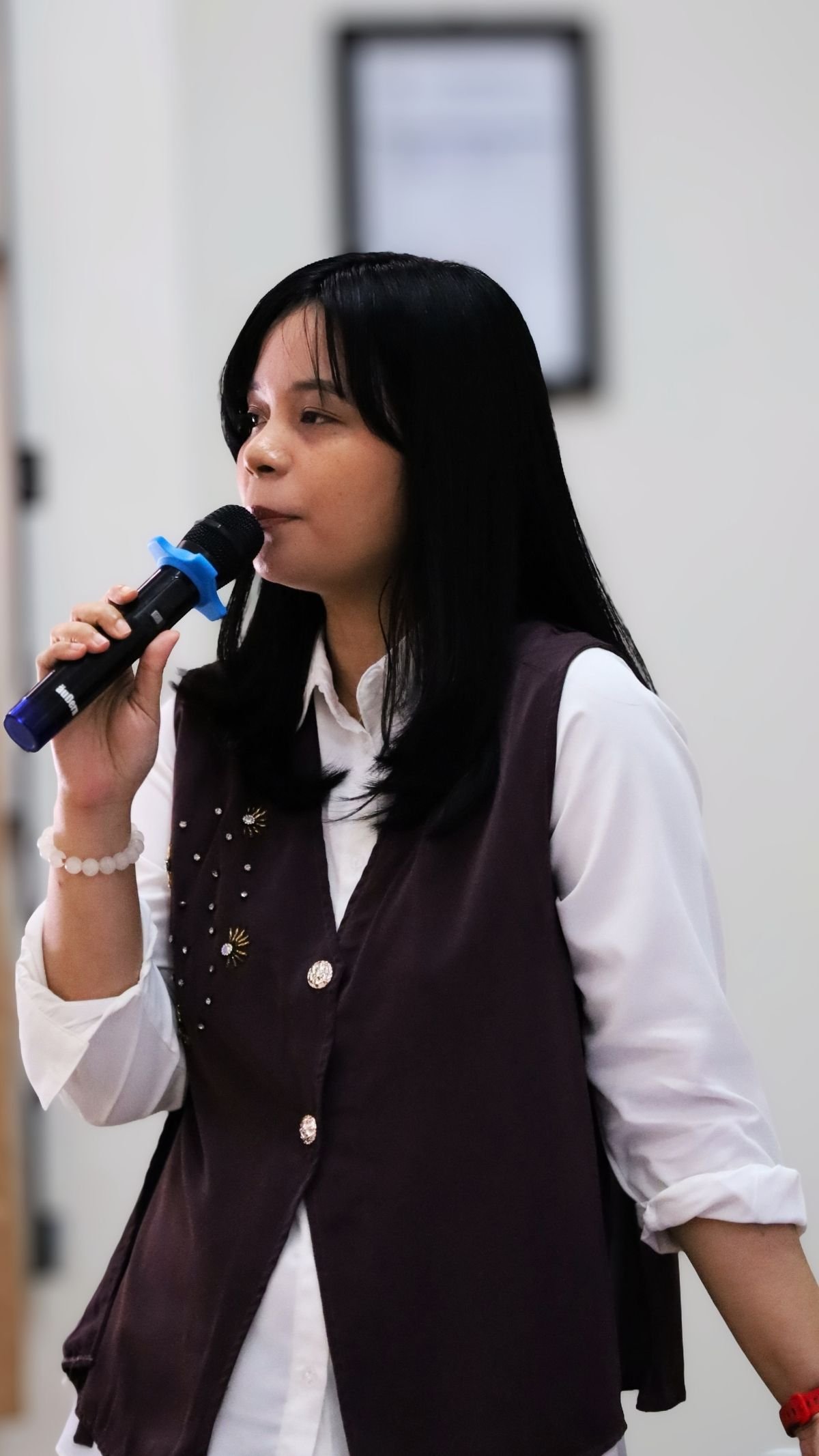 Narasumber perempuan berbicara menggunakan mikrofon saat kegiatan pelatihan.